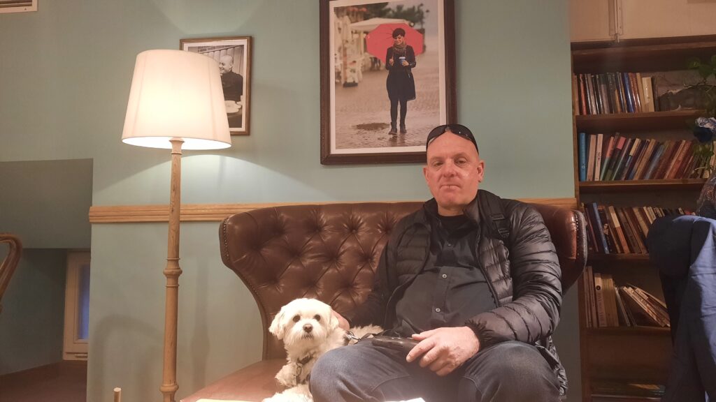 Sofus the dog is sitting in a couch with Carl in Caffe Nero Green