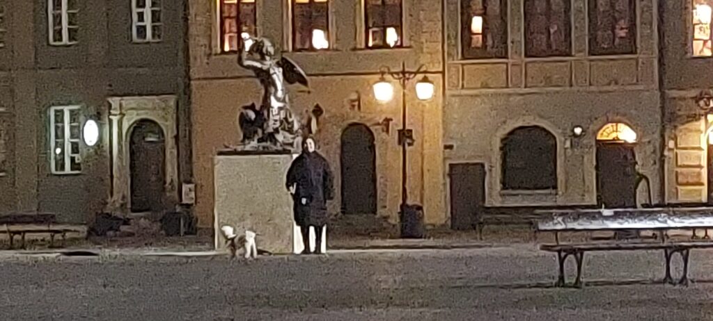 Karen with Sofus on his lead beside the bronze Warsaw Mermaid statue in the Old Town, on one of their daily walks